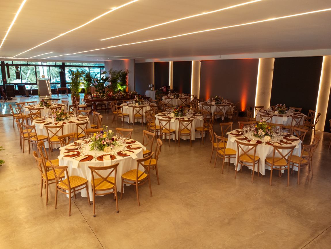 Salão montado em banquete com mesas redondas